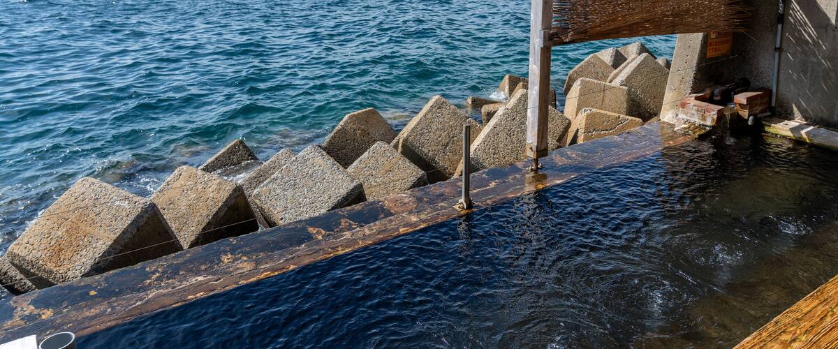 A pier with a wooden structure and stone bollards extending into the water.