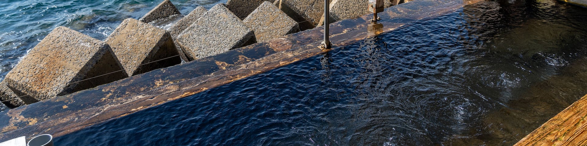 A pier with a wooden structure and stone bollards extending into the water.