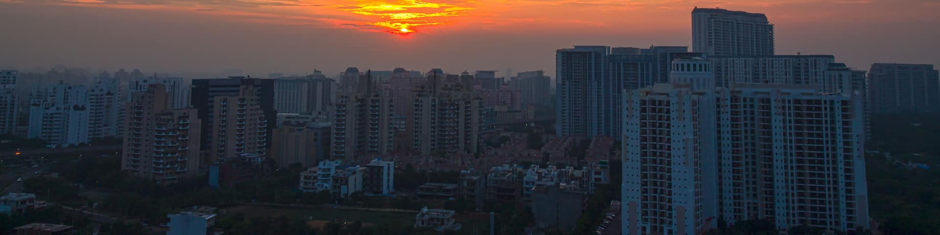 A city skyline at sunset with a vibrant sky and tall buildings.