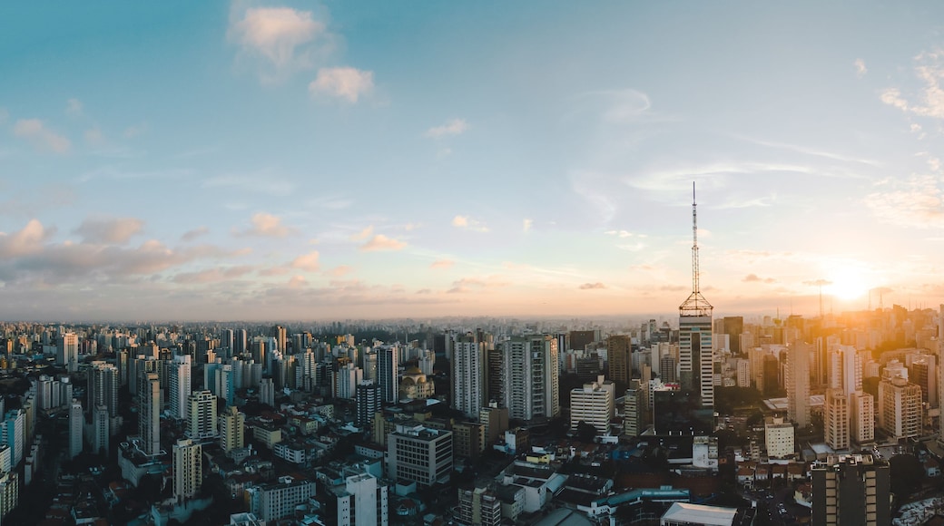 A cityscape with a prominent tower and a sunset.