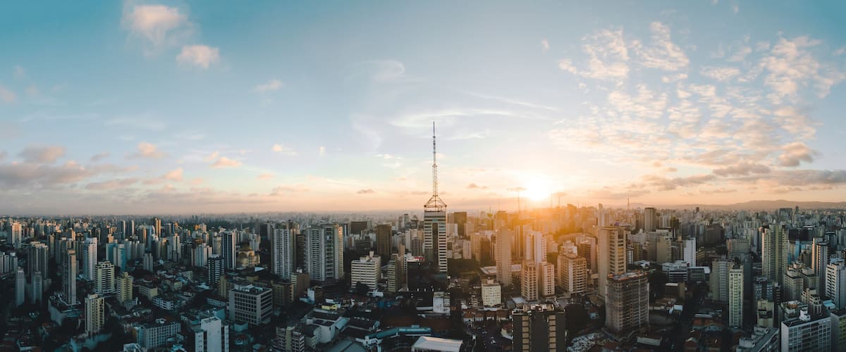 A cityscape with a prominent tower and a sunset.