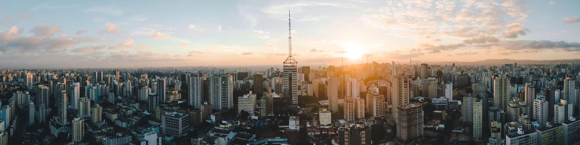 A cityscape with a prominent tower and a sunset.