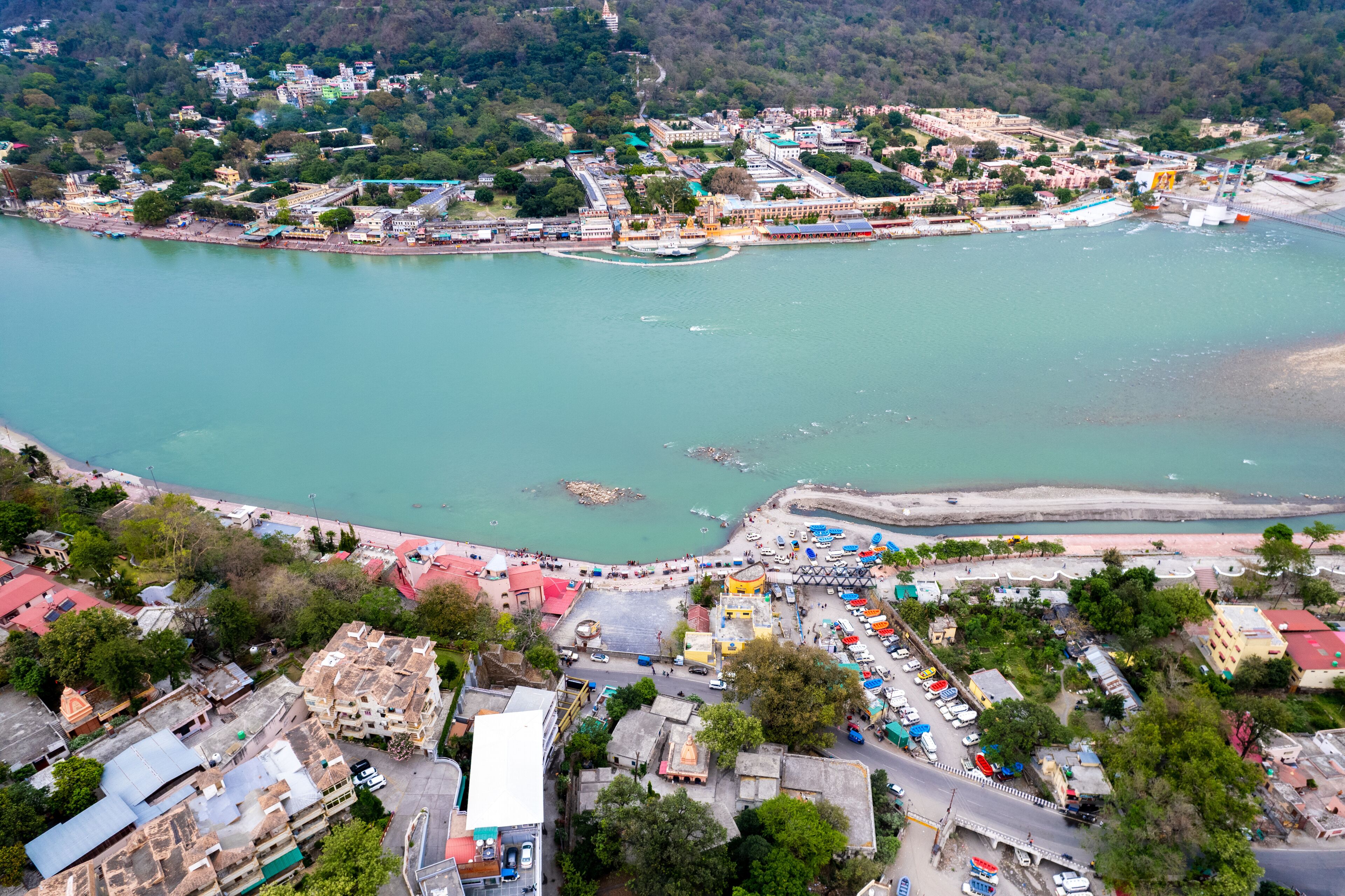 aerial drone shot over ram setu jhula suspension bridge with temples on the bank of river ganga in the holy spiritual city of Rishikesh Haridwar uttarakhand