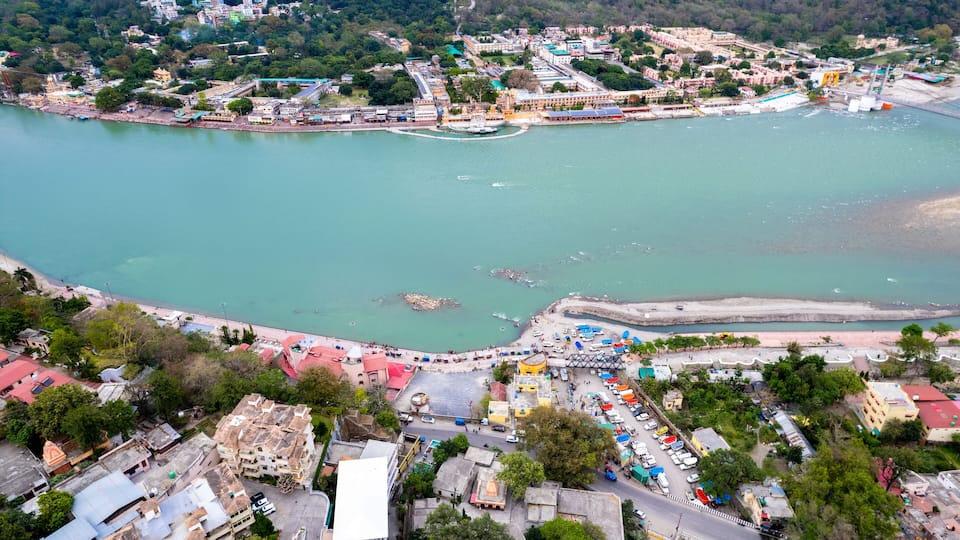 aerial drone shot over ram setu jhula suspension bridge with temples on the bank of river ganga in the holy spiritual city of Rishikesh Haridwar uttarakhand