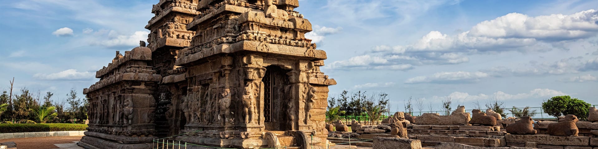 An ancient temple with intricate carvings and multiple spires, set against a clear blue sky.