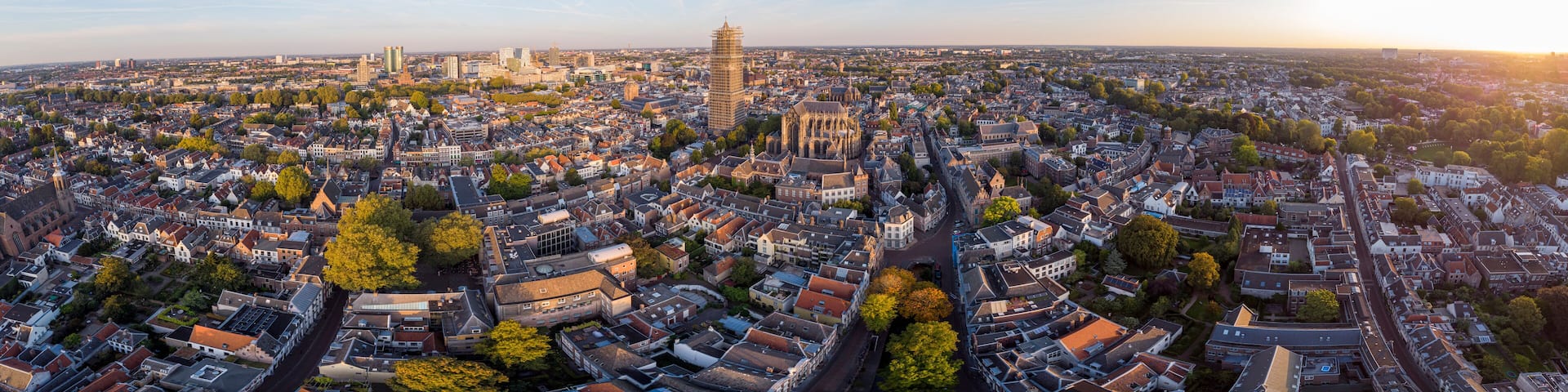 A panoramic view of a city with a prominent tower, historic buildings, and a cathedral.