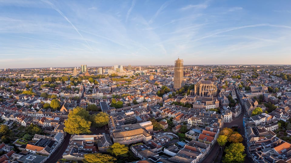 Wide panoramic aerial view of the medieval Dutch city centre of Utrecht with cathedral towering over the city at early morning sunrise. Cityscape in The Netherlands