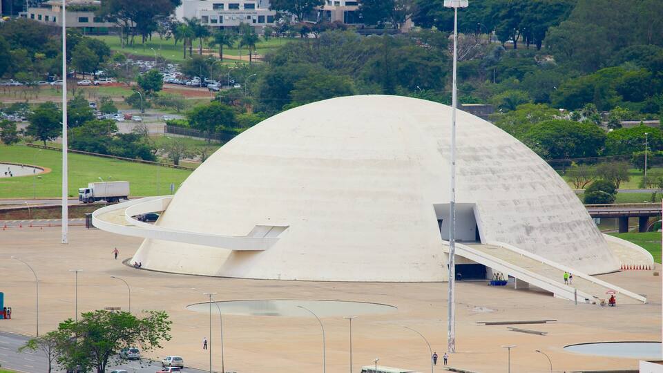 A large white dome-shaped building with a ramp leading up to it, surrounded by a parking lot and greenery.