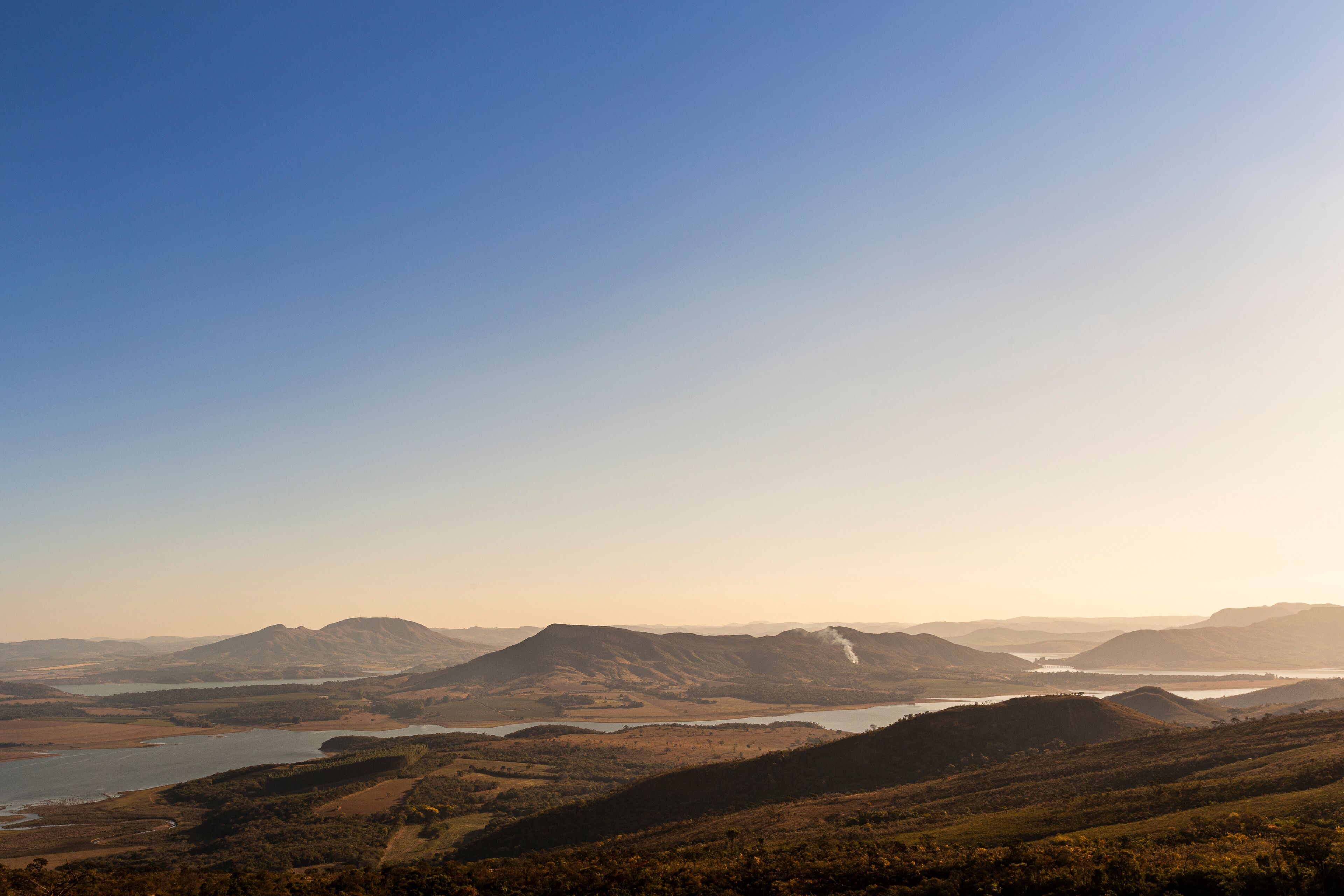 A mountainous landscape with a river and hills.