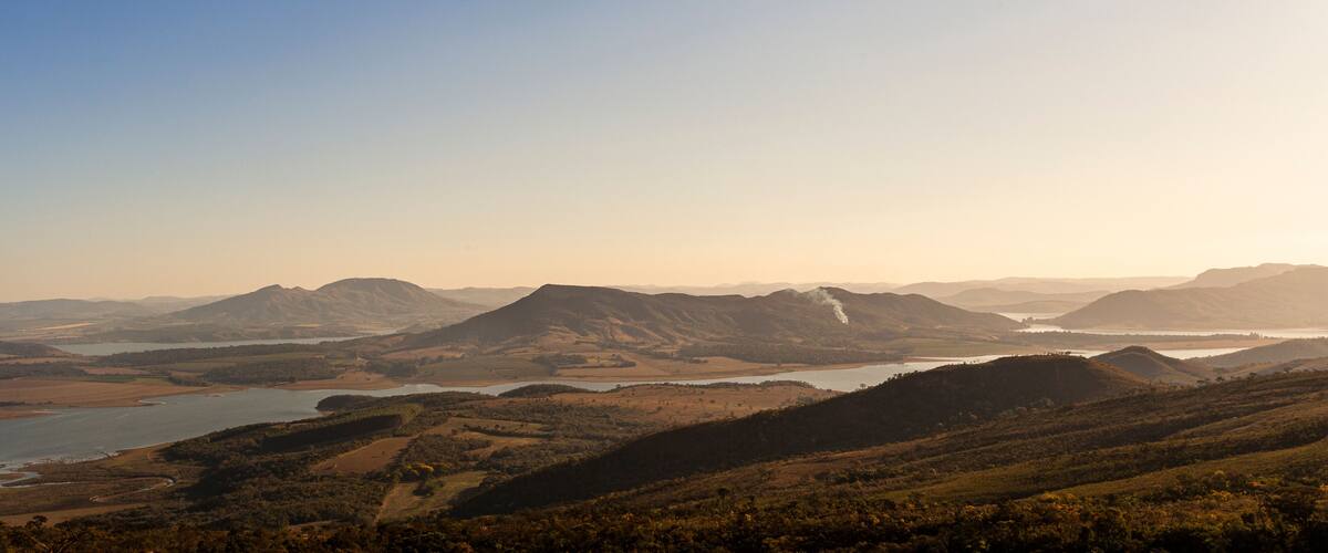 A mountainous landscape with a river and hills.
