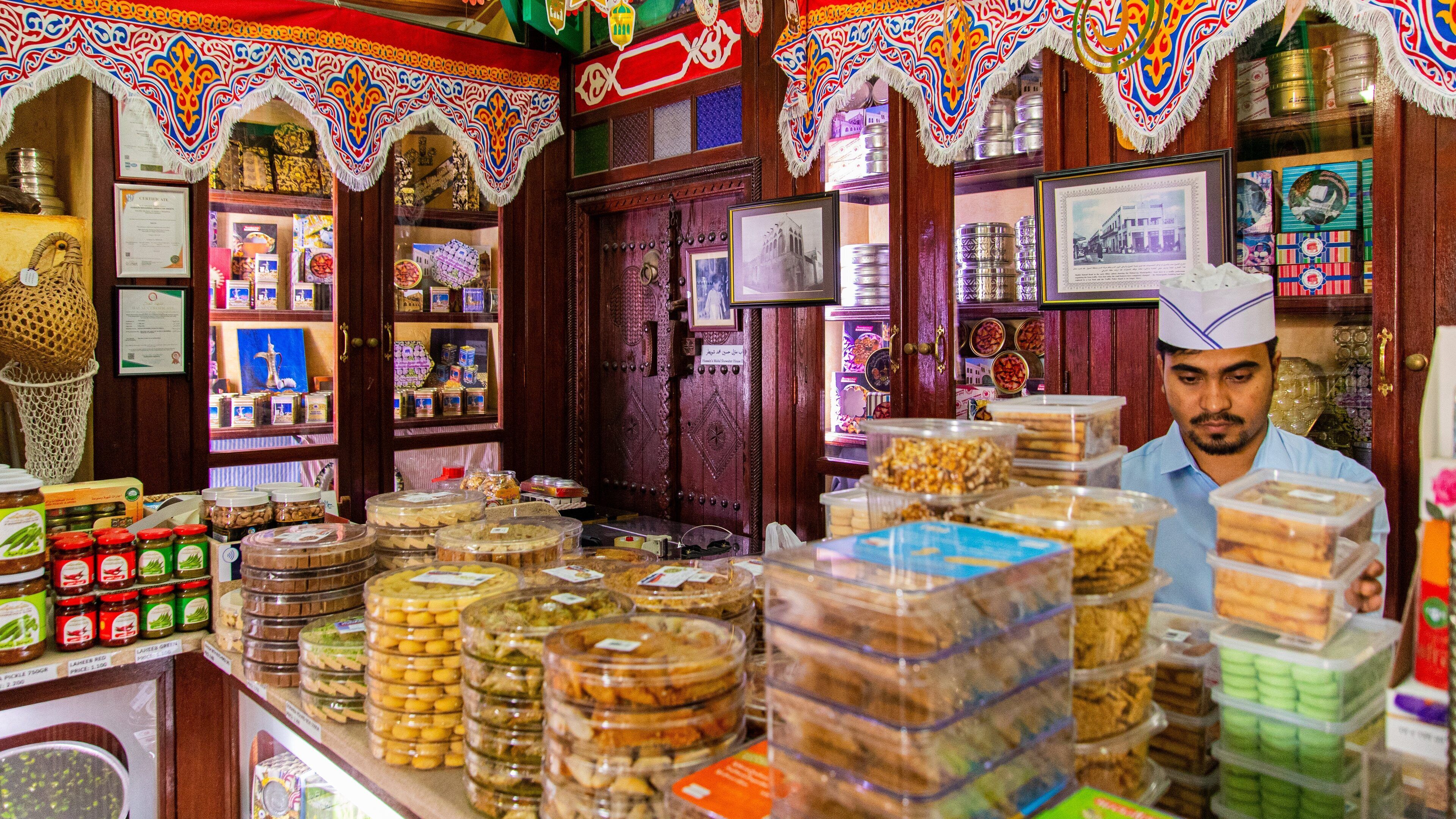 Muharraq Souq featuring interior views and food as well as an individual male