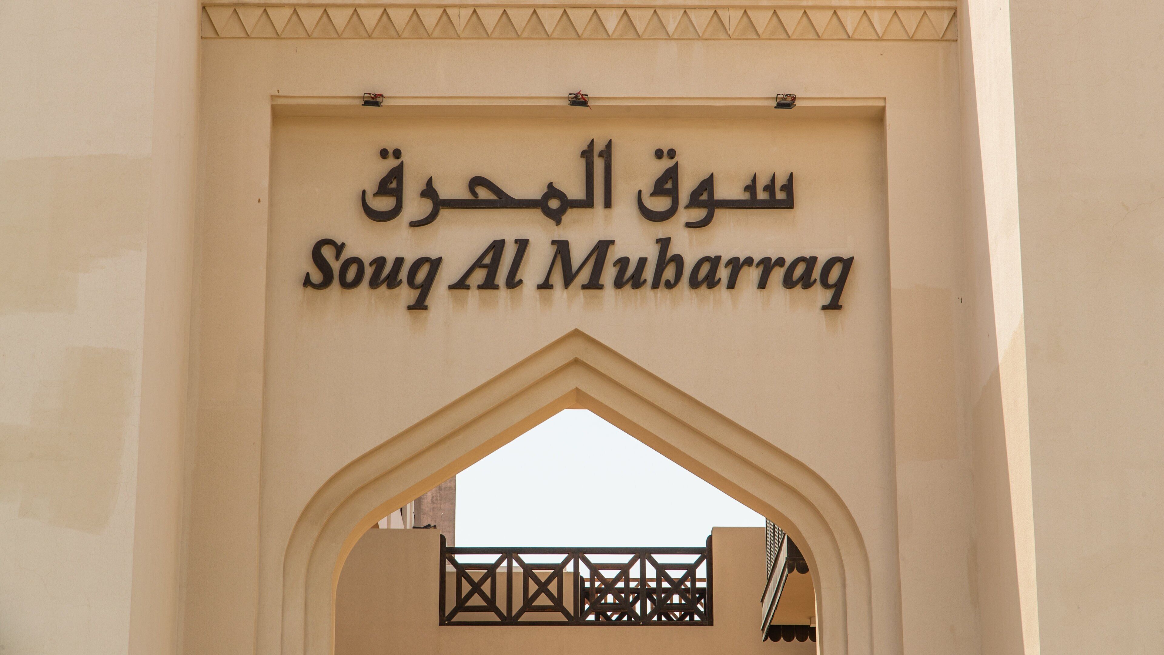 Ein Eingangsbogen mit der Beschriftung 'Souq Al Muharraq' in Arabisch und Englisch.