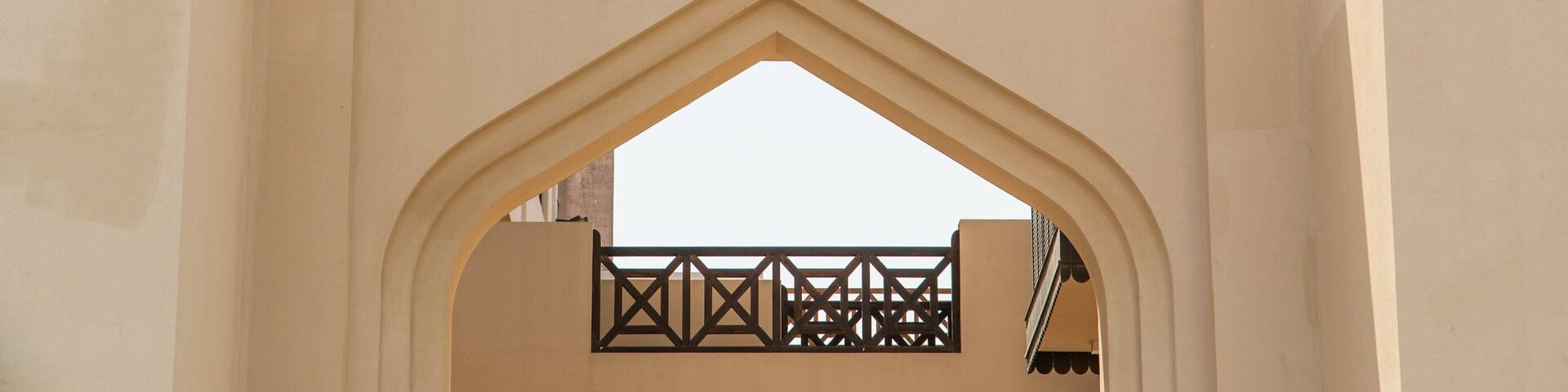 Un arco de entrada con el letrero "Souq Al Muharraq" en árabe e inglés.