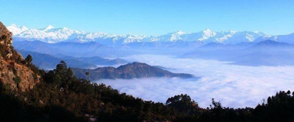 A mountain range with snow-capped peaks and a valley below.