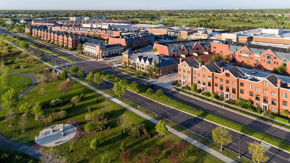 A large campus with red brick buildings, wide roads, and green landscaping.