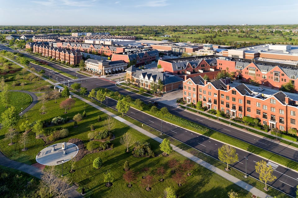 Un campus extenso con edificios de ladrillo rojo, amplias avenidas y jardines frondosos.