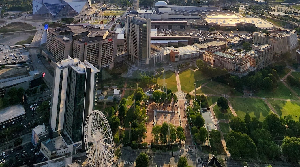 the city skyline at sunset with Mercedes-Benz Stadium, the SkyView Atlanta Ferris wheel, office buildings, hotels and apartments with cars at The Sun Dial Restaurant in Atlanta Georgia USA