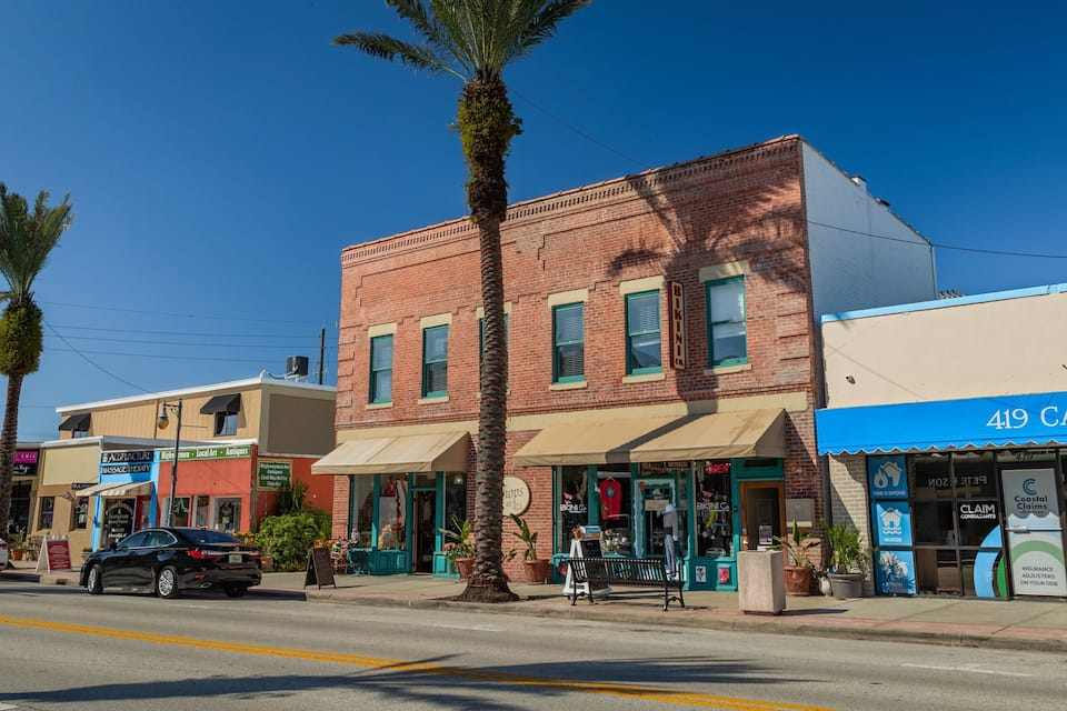 A street with palm trees, a black car, and storefronts including 'Bikini' and '419 Canal'.