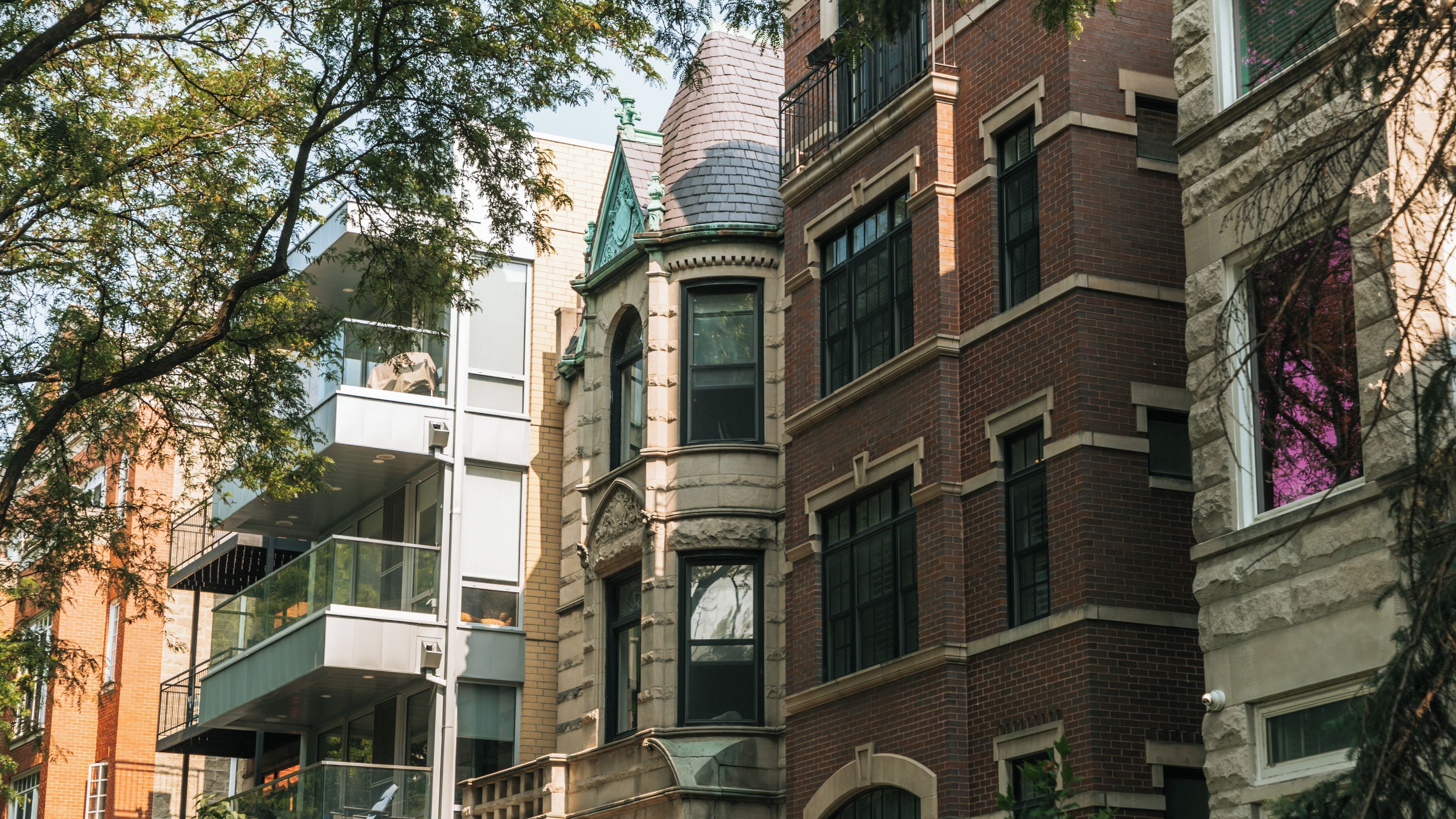A row of multi-story buildings with a mix of architectural styles, including brick and modern glass facades.