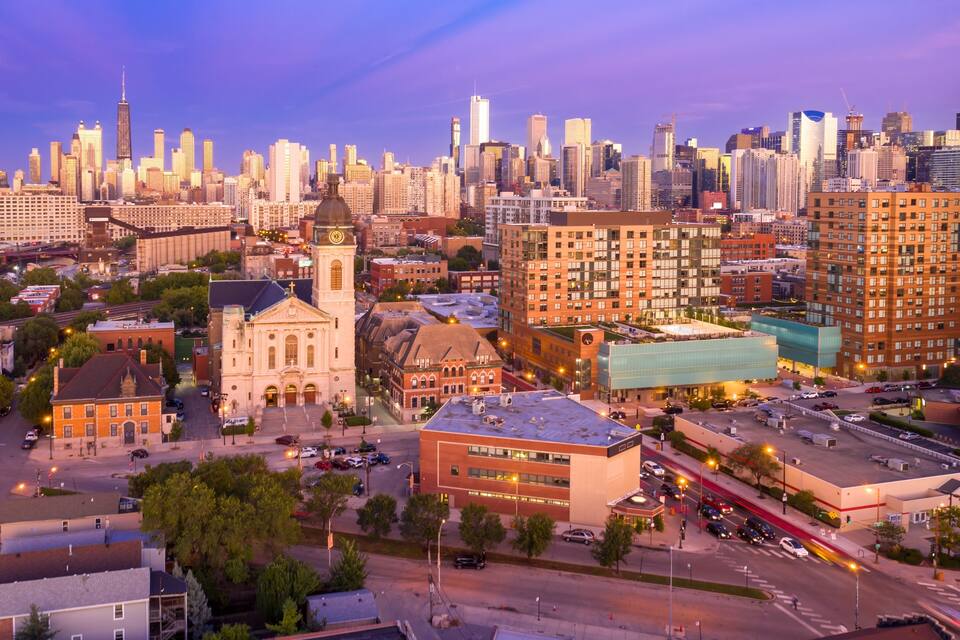 A cityscape with a prominent clock tower, a mix of modern and historic buildings, and a dense skyline.