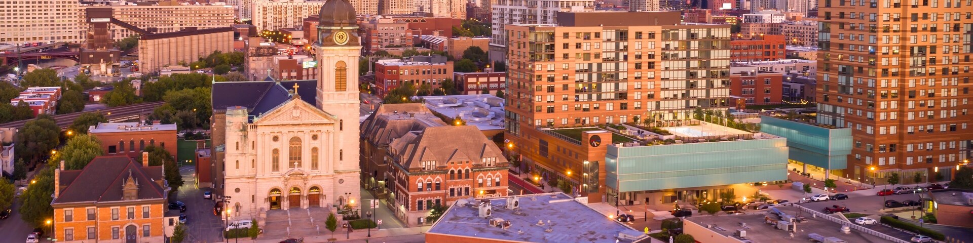 Chicago cityscape at twilight, featuring a mix of residential and commercial buildings, including a church and modern apartment complex. River West, Chicago, Illinois, United States