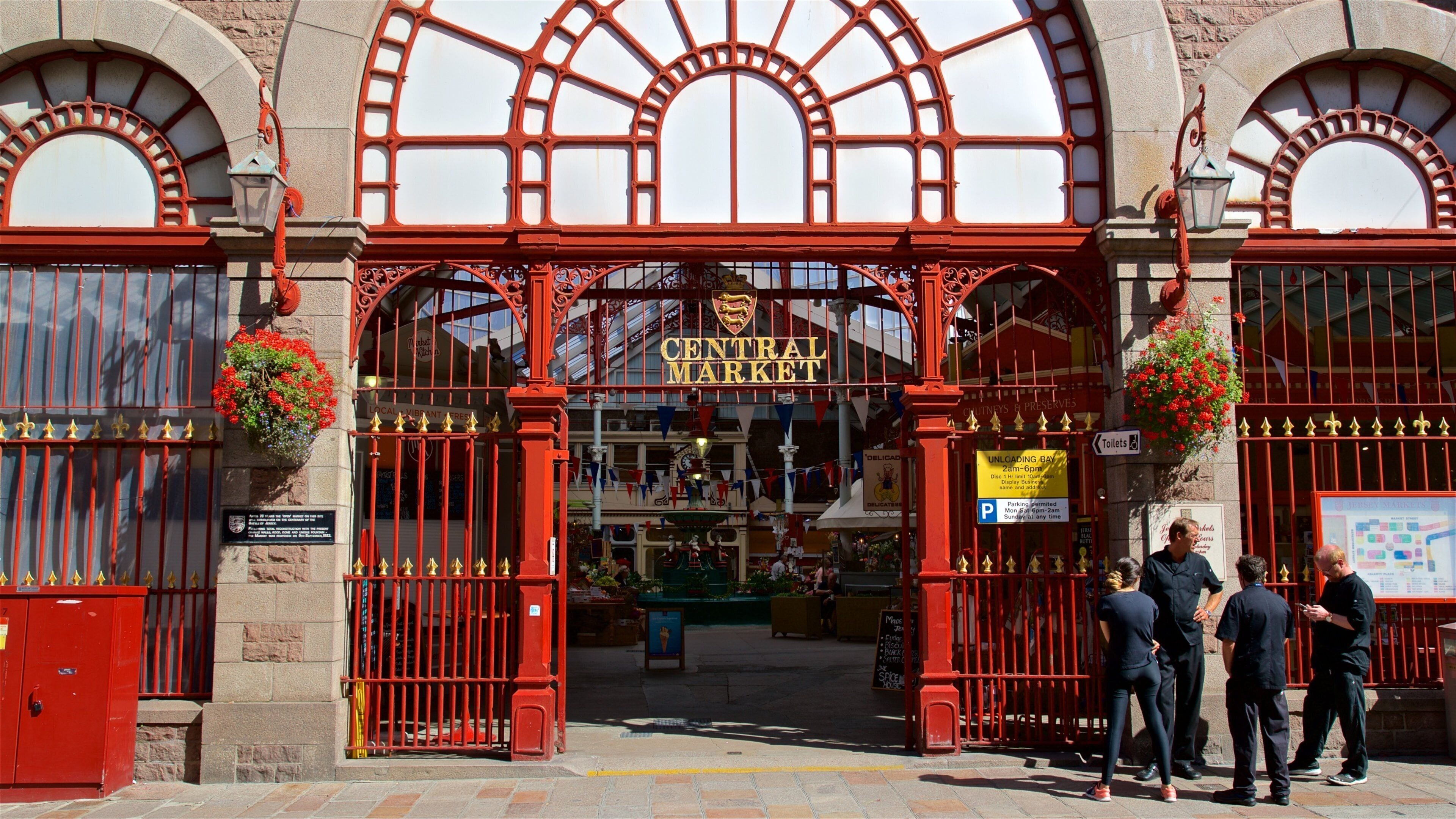 The entrance to Central Market with ornate red gates and hanging flower baskets.