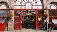 L'entrée du marché central, avec ses portails rouges richement décorés et ses paniers de fleurs suspendus.