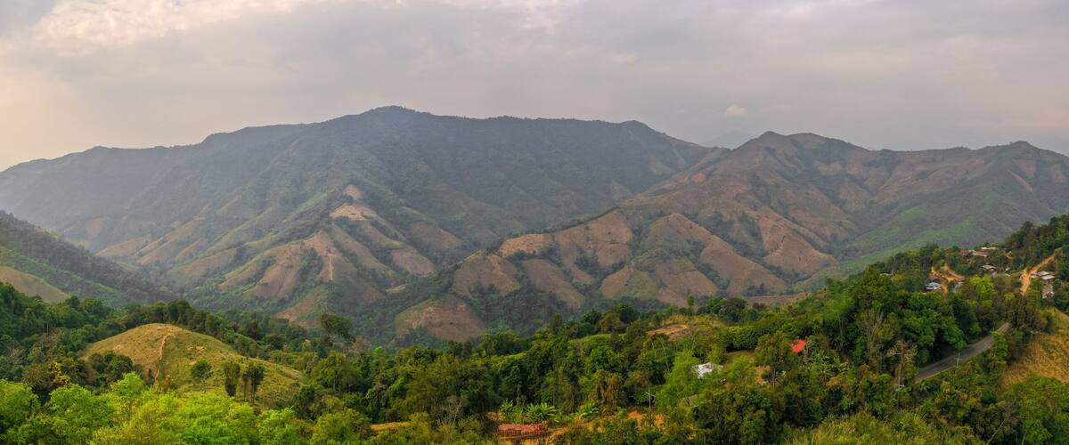 A mountainous landscape with lush green hills and a winding road.