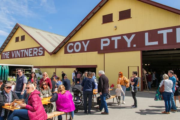 Barossa Farmers Market showing outdoor eating and signage as well as a small group of people