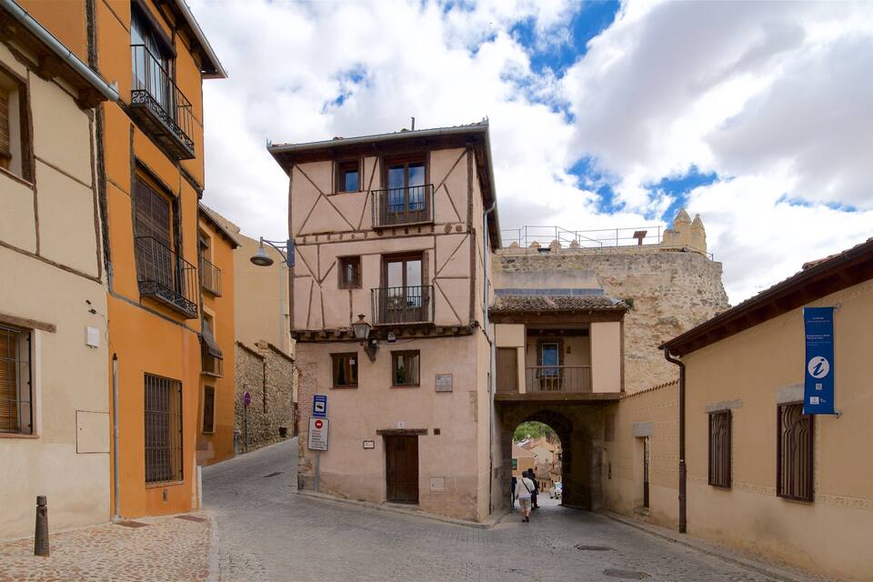A narrow cobblestone street flanked by historic buildings with exposed wooden beams and stone walls.