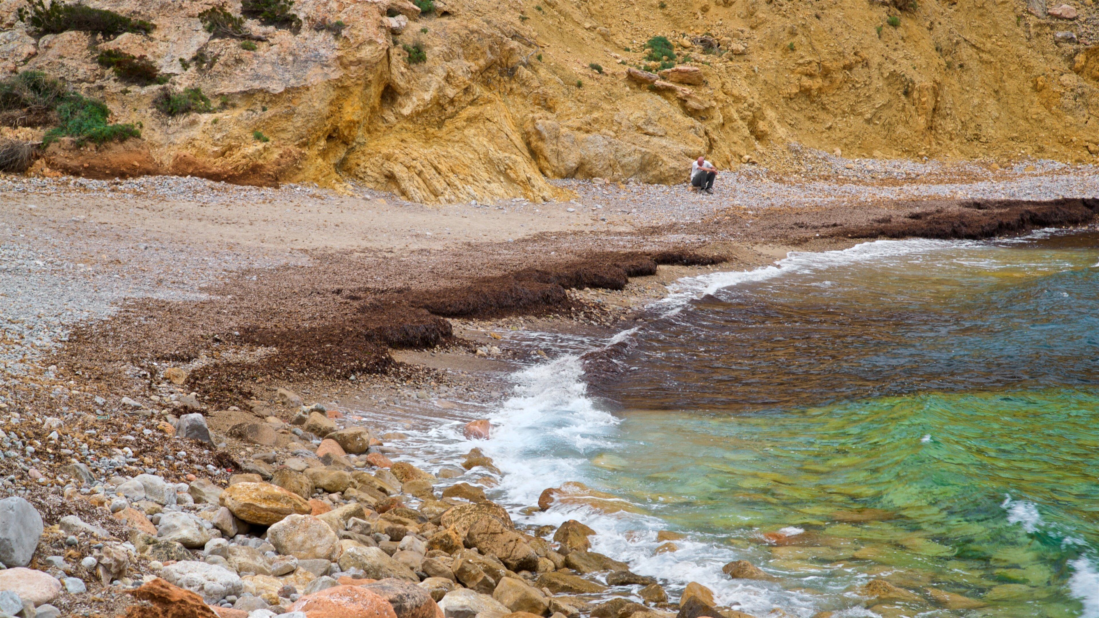 Cala Codolar featuring rocky coastline, general coastal views and a pebble beach