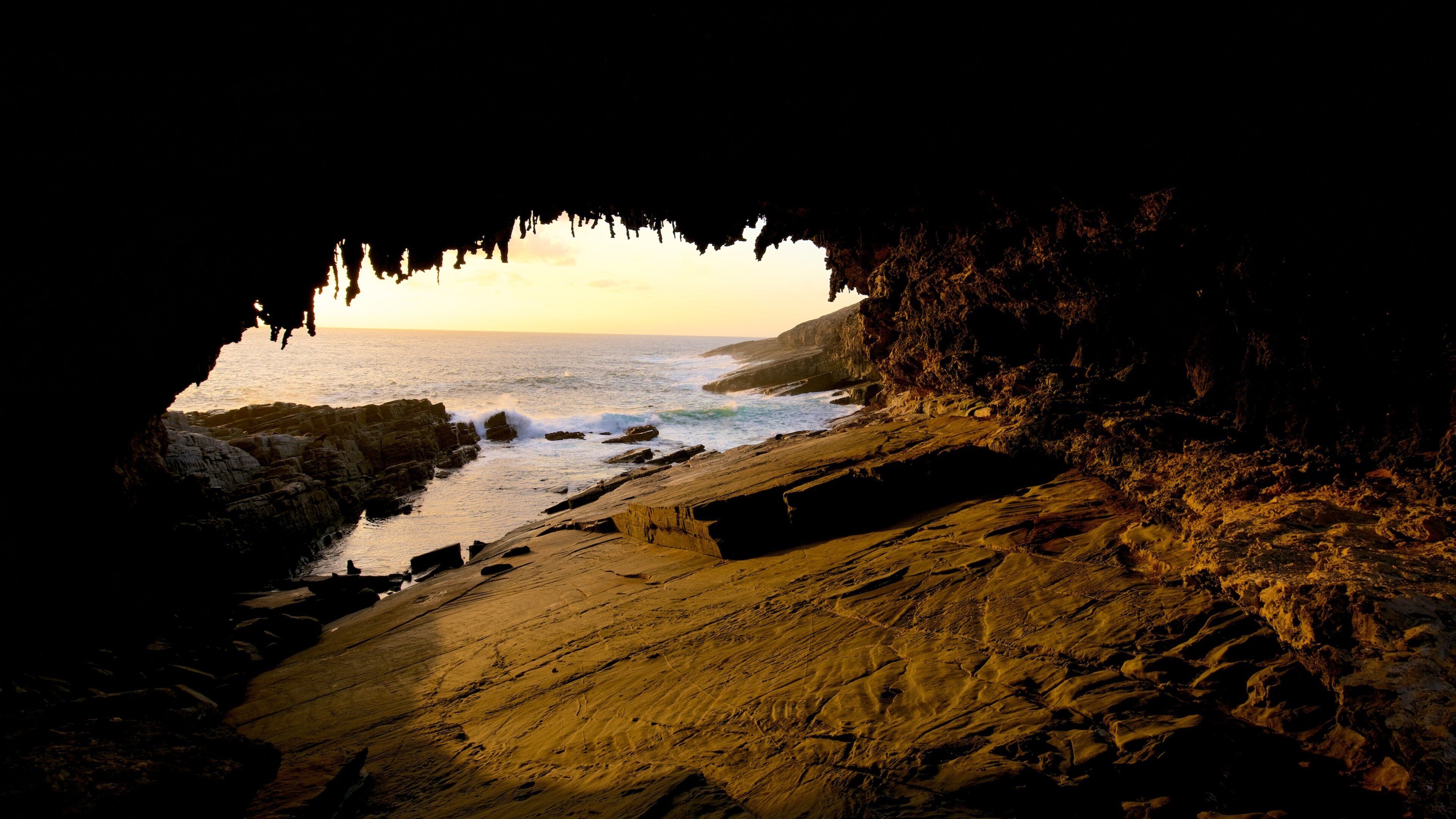 Admirals Arch featuring a sunset, caves and general coastal views