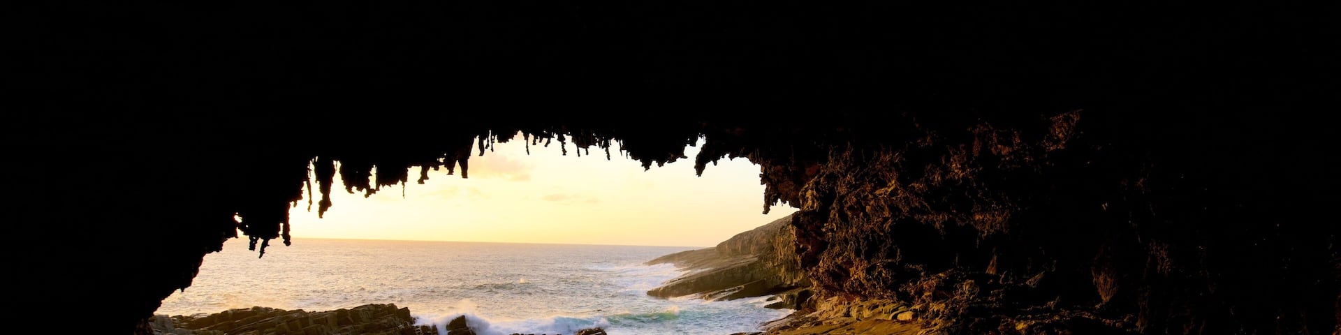Admirals Arch featuring a sunset, caves and general coastal views