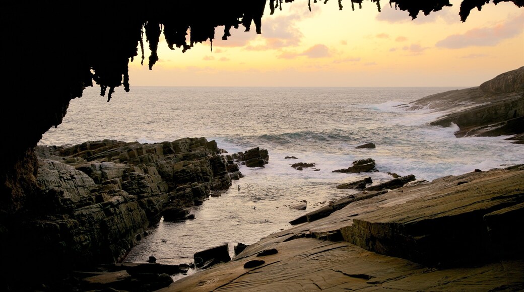 Admirals Arch featuring caves, general coastal views and a sunset