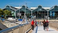 A pedestrian bridge with a glass building in the background labeled "PIC" and "JEANIE JOHNSTON".