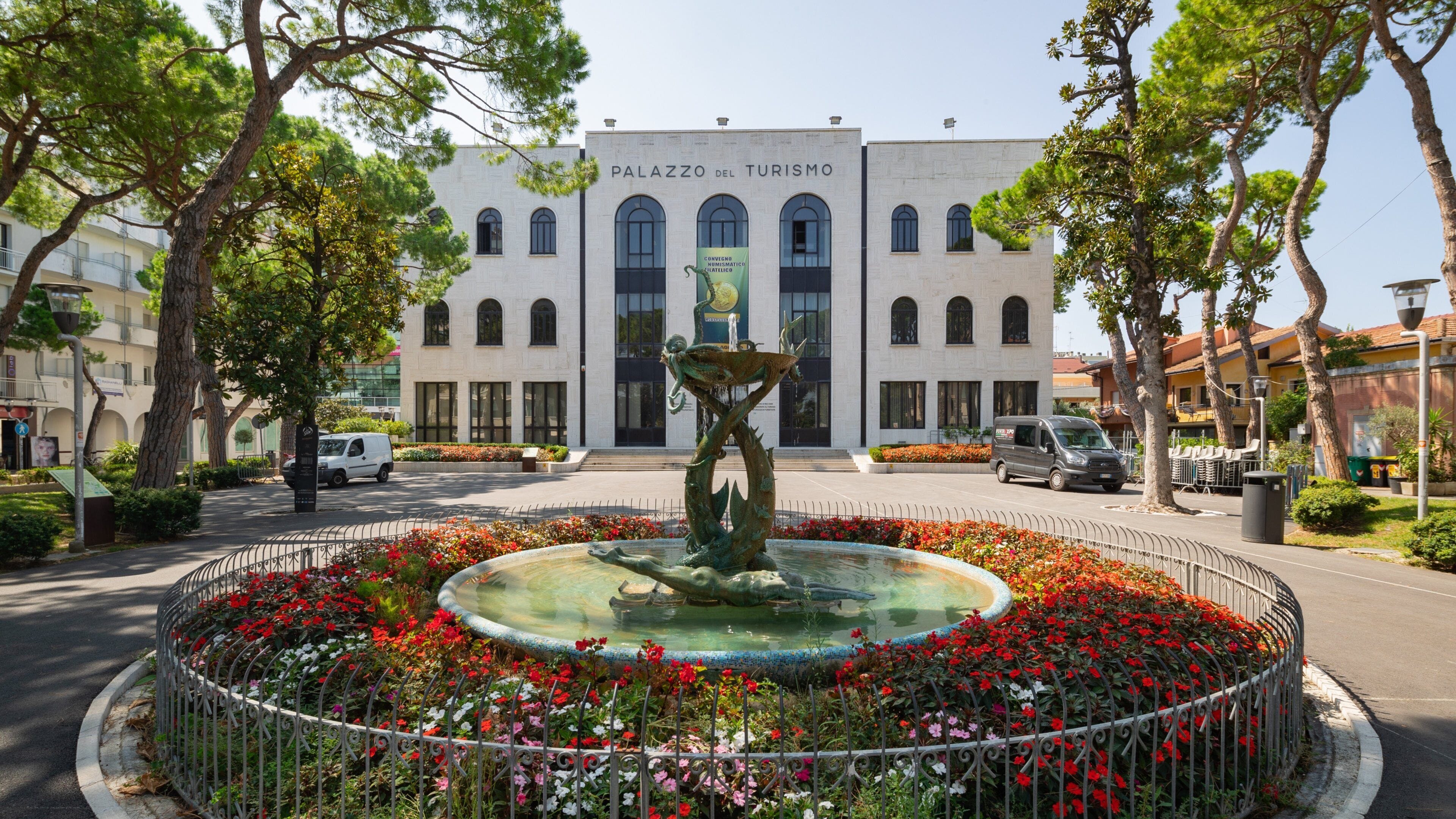 Palazzo Del Turismo featuring flowers and a fountain