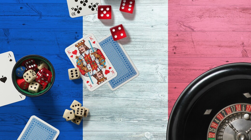 France casino theme. Aces in poker game, cards and chips on red table with national wooden flag background. Gambling and betting.
