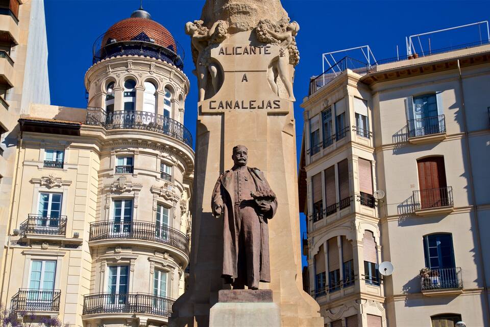 Een standbeeld van een man met hoed en wandelstok, op een voetstuk met de tekst ‘Alicante a Canalejas’.
