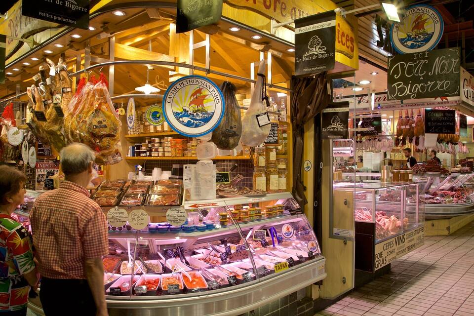 A market stall with various food items and a sign indicating 'Le Noir de Bigorre'.
