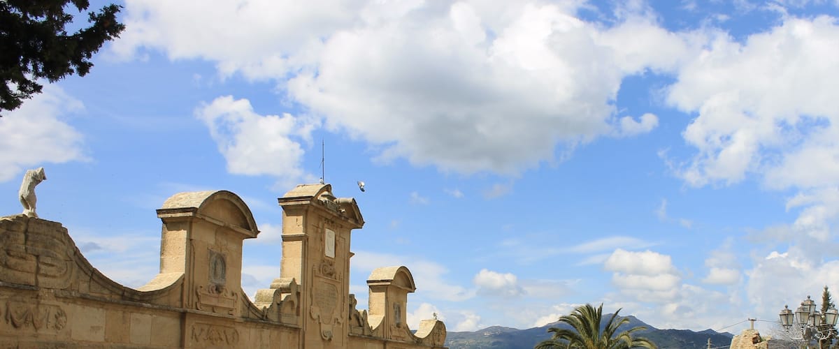 Un edificio histórico de piedra con arcos y una fuente.
