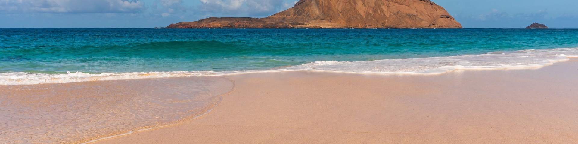 Amazing beach with untouched sand and turquoise waters on a sunny summer day landscape. La Conchas beach (Playa de las Conchas) on La Graciosa Island, Canary, Spain.