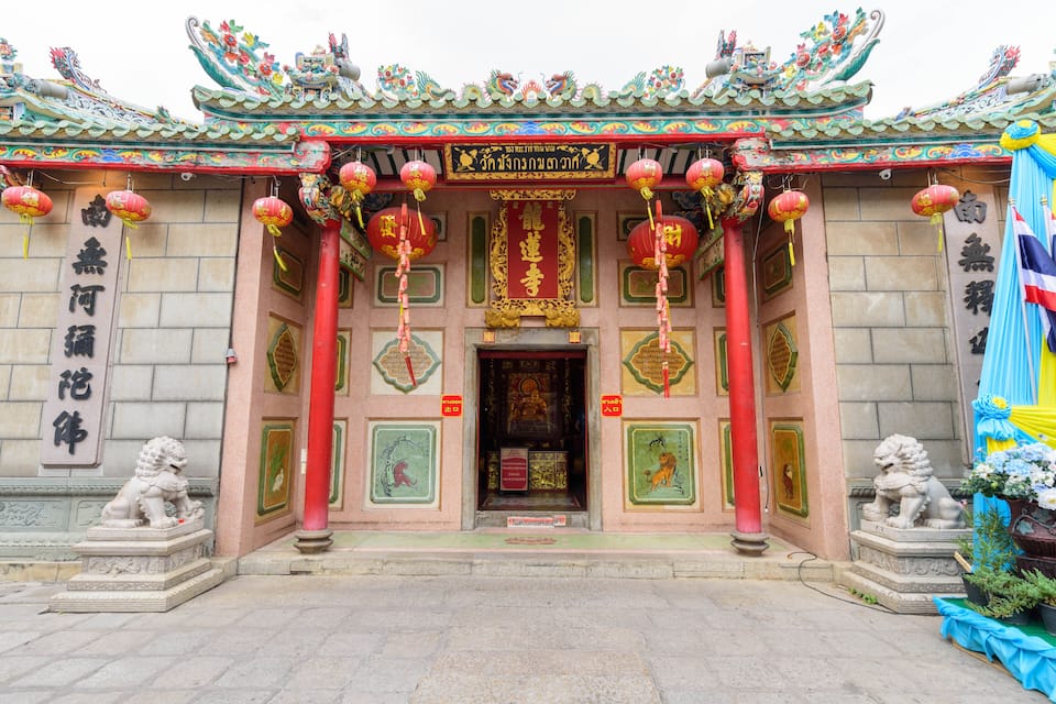 A traditional Chinese temple with ornate architecture, red lanterns, and lion statues.