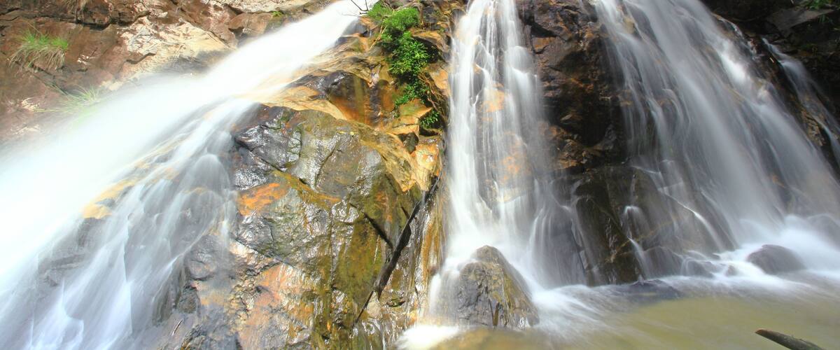 A waterfall cascading over rocks in a forested area.