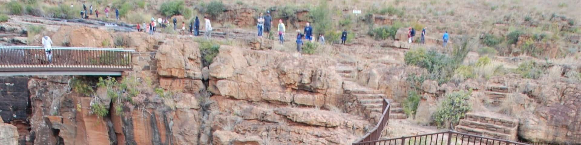 A large rock formation with a waterfall at its base.