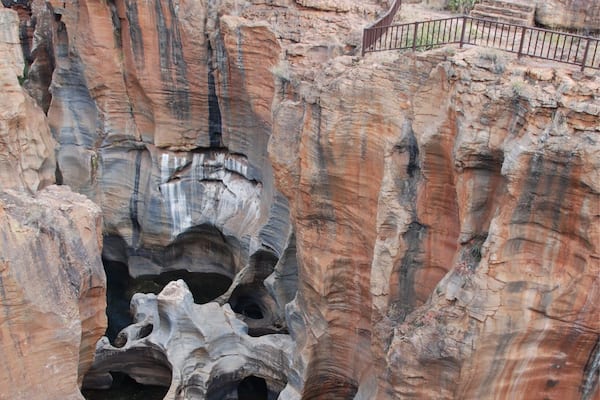 A large rock formation with a waterfall at its base.
