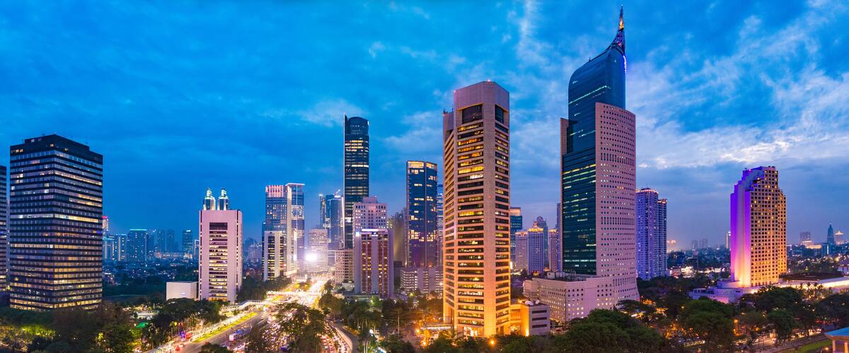 Aerial view of Jakarta's Central Business District at dusk (blue hour). Jakarta cityscape at sunset. A panorama stitched from 3 photos. Jakarta cityscape. Widescreen photo.