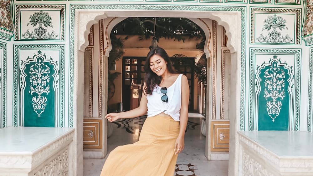 Woman in brown skirt standing at Gate of Shahpura House, Shekhawati, Rajputana, India