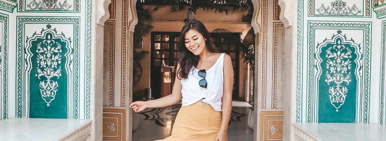 Woman in brown skirt standing at Gate of Shahpura House, Shekhawati, Rajputana, India