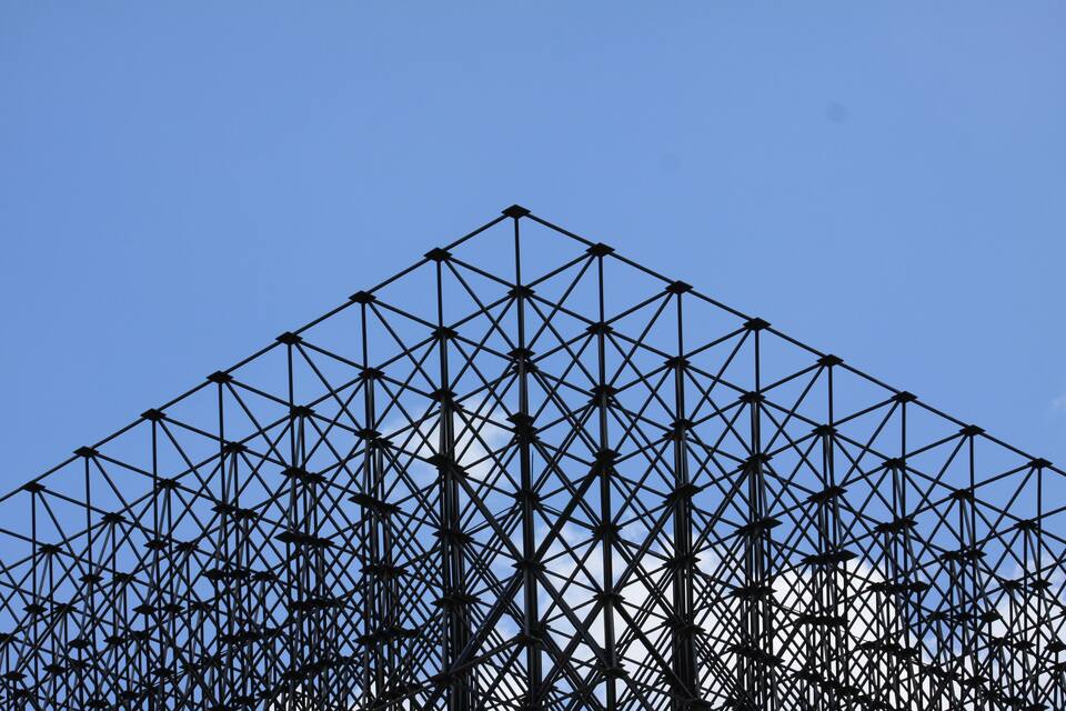 Una estructura metálica geométrica contra un cielo azul despejado.