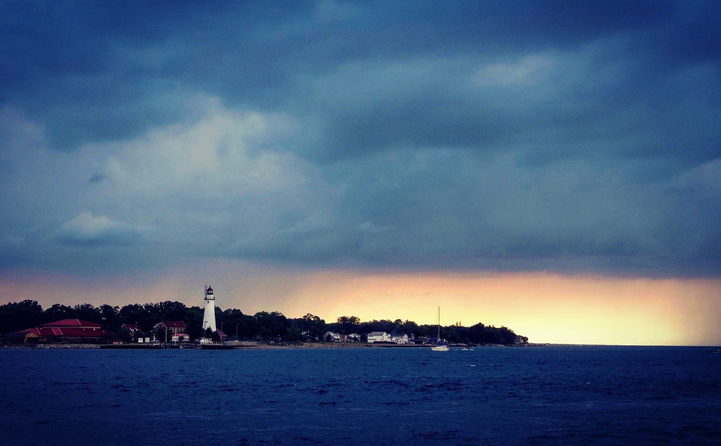 Lighthouse on the Michigan shore with a storm passing over Lake Huron.